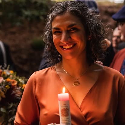 Nikole Sunshine smiling, holding a lit candle